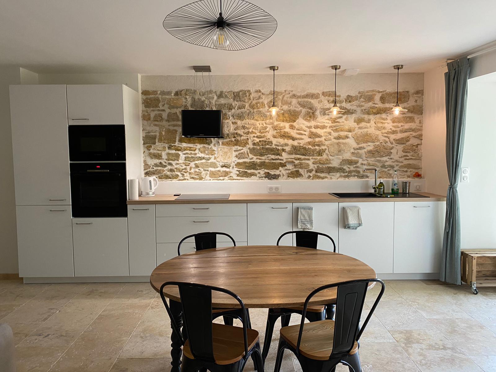 Cuisine avec mur en pierres apparentes au Gîte des Nines à La Chapelle en Vercors