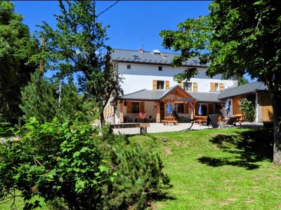 Vue du Gîte les Carlines entouré de forêt